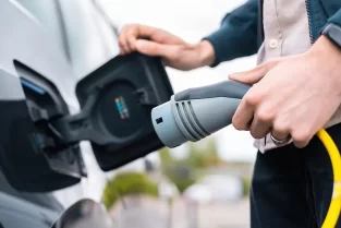 man-opening-cars-charge-socket-holding-charger-charge-station